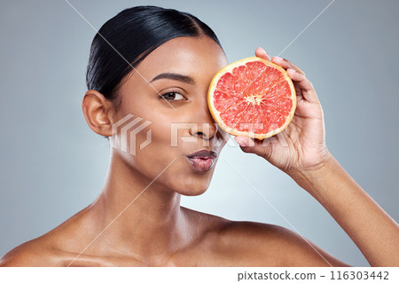 Indian woman, grapefruit and skincare for organic beauty, hand and fruit on gray background. Citrus, pout and vitamin c with acid for balanced skin or body care, studio and female person for detox 116303442