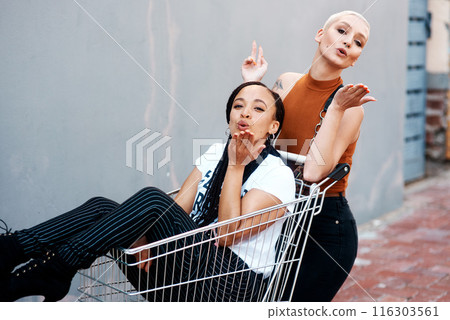 Friends, portrait and shopping cart for blowing kiss, outdoor and bonding together in city for love. Women, town and adventure in trolley for support, emoji and flirting gesture in urban on weekend Friends, portrait and shopping cart for blowing kiss, outdoor and bonding together in city for love. Women, town and adventure in trolley for support, emoji and flirting gesture in urban on weekend 116303561