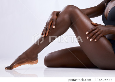 Black person, legs and skincare in studio for hair removal, epilation and smooth skin on white background. Body, woman and hands touching with manicure for wellness, waxing or moisturize and beauty Black person, legs and skincare in studio for hair removal, epilation and smooth skin on white background. Body, woman and hands touching with manicure for wellness, waxing or moisturize and beauty 116303672