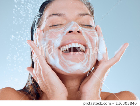 Woman, facial and soap in shower for skincare hygiene, wash or clean against a blue studio background. Happy, splash and model person for wellness of face, healthy treatment by water or cosmetics Woman, facial and soap in shower for skincare hygiene, wash or clean against a blue studio background. Happy, splash and model person for wellness of face, healthy treatment by water or cosmetics 116303840