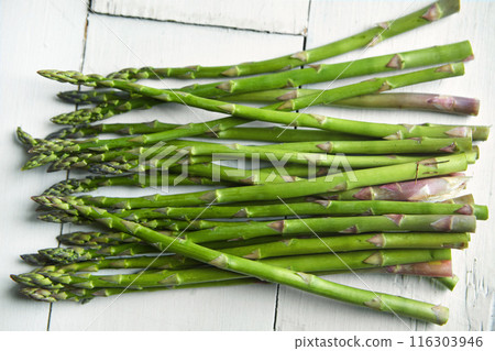 Asparagus, kitchen and food on table for health, lunch or decision with nutrition for wellness. Organic vegetable, cooking and choice for benefit on counter, detox or meal prep for vegan diet in home Asparagus, kitchen and food on table for health, lunch or decision with nutrition for wellness. Organic vegetable, cooking and choice for benefit on counter, detox or meal prep for vegan diet in home 116303946