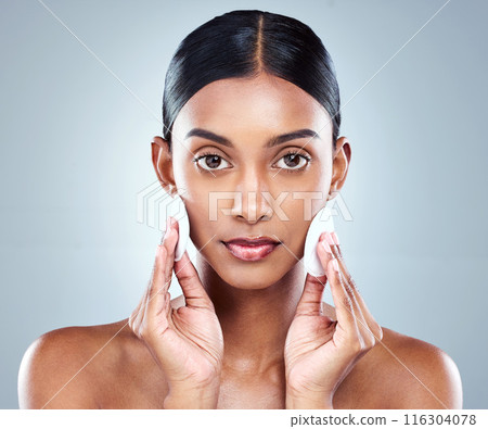 Portrait, Indian woman and skincare or cleansing, cotton pads and pamper for white background. Cosmetology, studio or hygiene routine for spot control, retinol or hyaluronic acid for female person 116304078