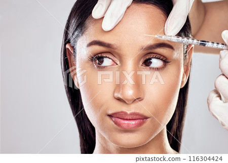 Hand, needle and woman in studio for plastic surgery with beauty transformation and cosmetic procedure. Surgeon injection, client and facial filler for anti aging results and glow by grey background 116304424