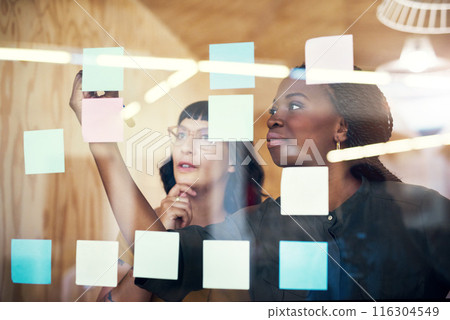 Women, writing on glass at startup and brainstorming, ideas and planning together in office. Employees, people and teamwork by moodboard with thinking, mindmap or sticky note at creative agency Women, writing on glass at startup and brainstorming, ideas and planning together in office. Employees, people and teamwork by moodboard with thinking, mindmap or sticky note at creative agency 116304549