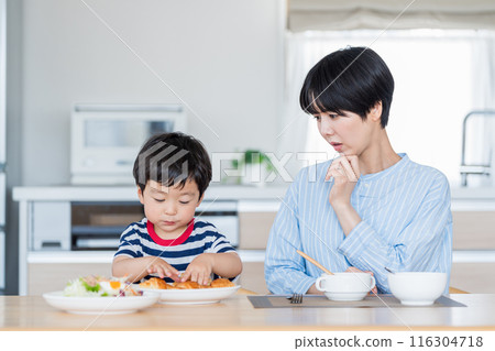 A child eating with his mother who is concerned about nutritional education. 116304718