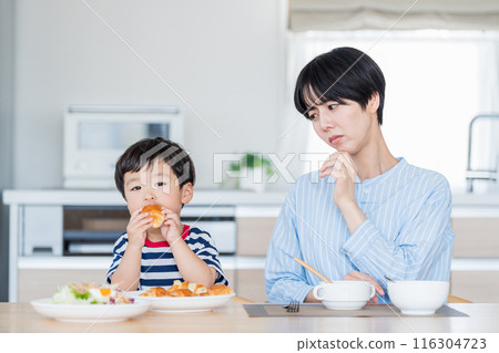 A child eating with his mother who is concerned about nutritional education. 116304723