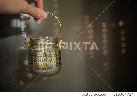 Hand holding candle holder 116304724