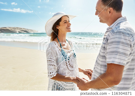 Love, holding hands and happy couple at a beach with conversation, trust and support while bonding in nature. Travel, marriage and people at the ocean for sunrise date, adventure and talking at sea 116304871