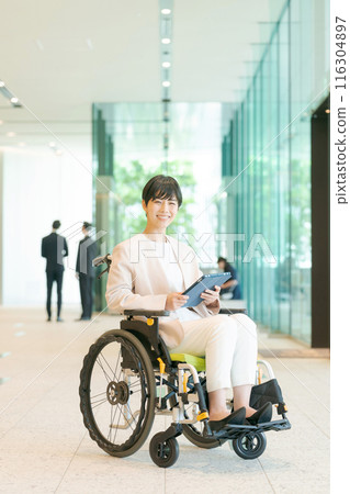 Woman in wheelchair working in office Woman in wheelchair working in office 116304897