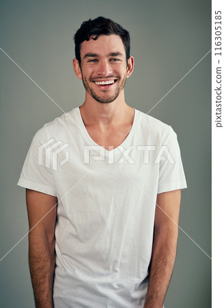 Happy, laughing and portrait of man with confidence in studio for good mood, joy and funny joke. Relax, male person and face with smile for humor, comedy meme and satisfaction on gray background 116305185