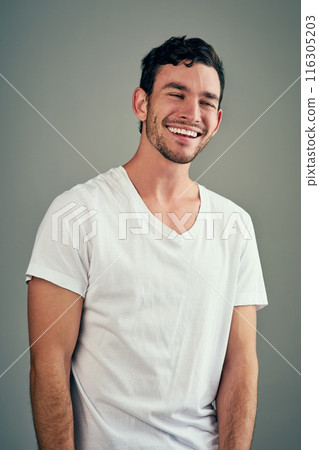 Smile, laughing and portrait of man in studio with funny joke, satisfaction and comedy meme. Relax, male person and face with happiness for humor, good mood and confidence on gray background 116305203