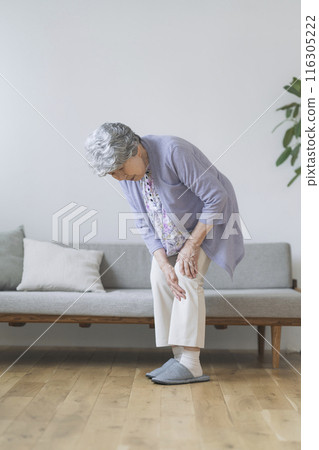 A woman in her 80s holding her knees 116305222