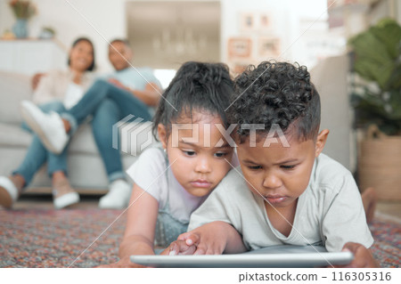 Children, tablet and online for streaming movies or gaming on floor together in family home. Young boy, girl and technology with internet for mobile app, ebook and social media or reading on weekend 116305316