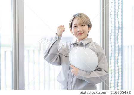 身穿工作服、頭戴頭盔、金髮短髮的年輕女子(握拳、自由髮色、以自己的方式工作) 身穿工作服、頭戴頭盔、金髮短髮的年輕女子(握拳、自由髮色、以自己的方式工作) 116305488