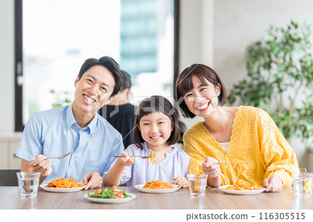 A family eating at a restaurant. A family eating at a restaurant. 116305515