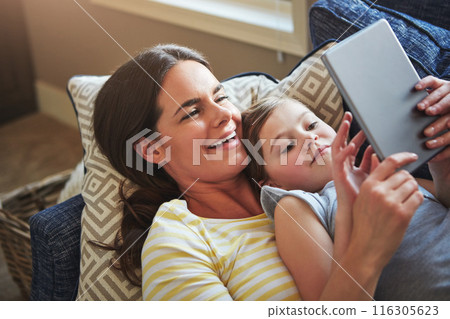 Tablet, mother and girl on sofa with internet for reading ebook, relationship love and streaming animation for fun in home. Child, mama and tech on couch with website for learning language and games 116305623