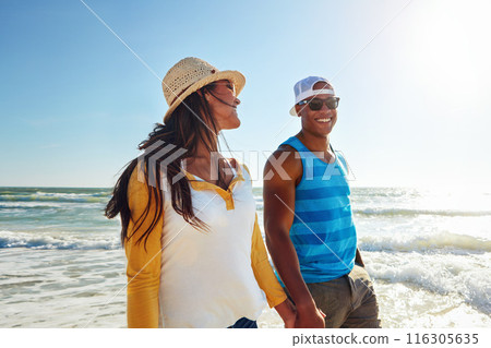 Couple, happy and walking at beach with sunglasses, sun and relax for vacation by ocean in summer. Man, woman and smile on sand in Bali with blue sky, sun and partner on date for holiday or love 116305635