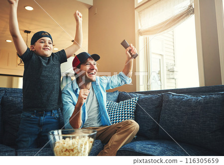 Television, kid and man with success on sofa for network, streaming and watching sports together. Son, dad and popcorn with tv remote in fist for celebration, bonding and live broadcast of match 116305659
