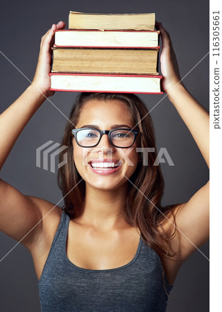 Portrait, happy woman and balance books in studio on head for learning, education or studying isolated on gray background. Student, face or textbook stack for knowledge, research or info with glasses 116305661