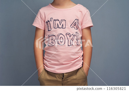 Boy, child and point at text on shirt for gender identity, style and edgy fashion model by gray background. Person, toddler or kid with pink clothes for choice, learning and show print with promotion Boy, child and point at text on shirt for gender identity, style and edgy fashion model by gray background. Person, toddler or kid with pink clothes for choice, learning and show print with promotion 116305821