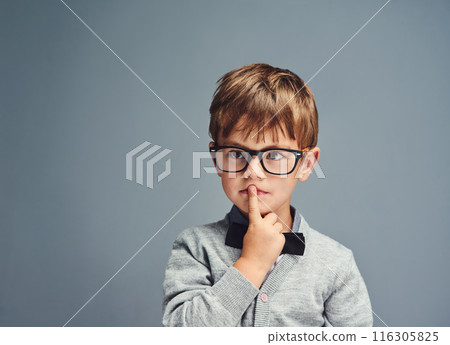 Fashion, glasses and thinking with boy genius in studio isolated on blue background for intelligence. Bowtie, idea and style with face of geek or nerd kid in trendy outfit for child development 116305825