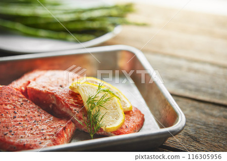 Gourmet, lemon and grilled salmon with asparagus for healthy, wellness and nutrition fine dining cuisine. Food, meal and diet dish of fish, vegetables and citrus fruit for dinner on wooden table. Gourmet, lemon and grilled salmon with asparagus for healthy, wellness and nutrition fine dining cuisine. Food, meal and diet dish of fish, vegetables and citrus fruit for dinner on wooden table. 116305956