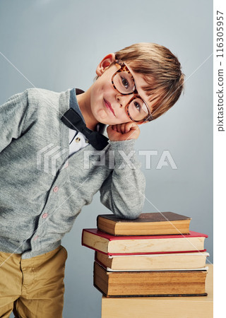 Boy, child and books in studio with glasses in portrait for reading, learning and smile by background. Kid, textbook and education with studying, scholarship and development for knowledge at school Boy, child and books in studio with glasses in portrait for reading, learning and smile by background. Kid, textbook and education with studying, scholarship and development for knowledge at school 116305957