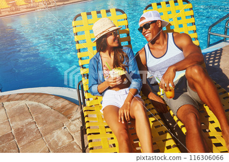 Couple, poolside and alcohol on holiday trip, outdoor and travel to hotel resort for vacation. People, peace and sunglasses by water for drinks, bonding and relax by swimming pool for wellness 116306066