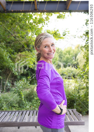 Outdoors, senior Caucasian female standing, smiling, hands on hips 116306293