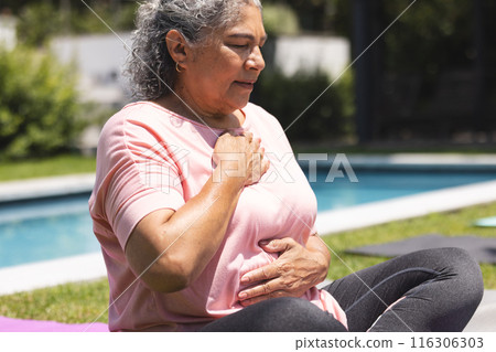 Outdoors, senior biracial woman practicing yoga by pool Outdoors, senior biracial woman practicing yoga by pool 116306303