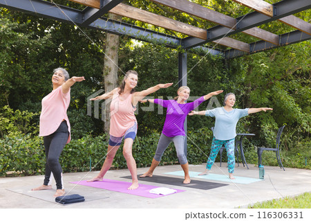 Diverse senior female friends practicing yoga outdoors, enjoying green background Diverse senior female friends practicing yoga outdoors, enjoying green background 116306331