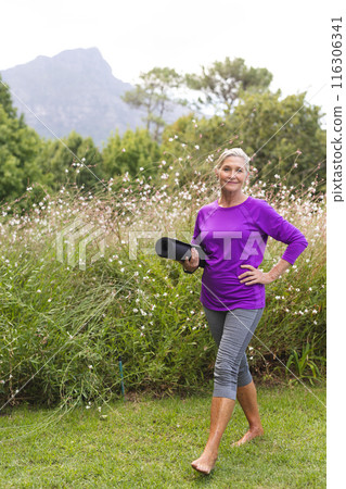 A senior Caucasian woman holding yoga mat enjoys outdoors A senior Caucasian woman holding yoga mat enjoys outdoors 116306341