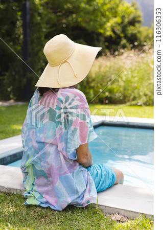 Outdoors, Caucasian senior woman wearing a hat, relaxing by pool Outdoors, Caucasian senior woman wearing a hat, relaxing by pool 116306353