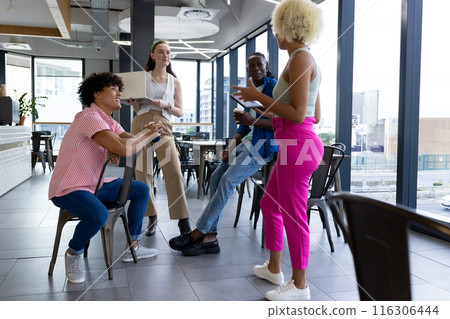 In modern office, a diverse young team engaging in discussion 116306444