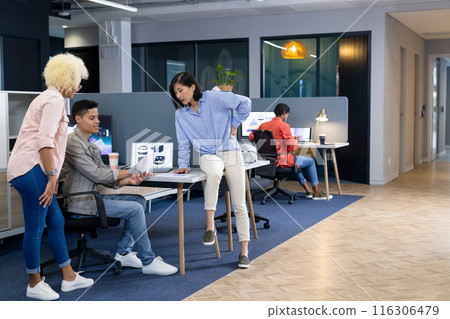 In modern office, diverse young team discussing work 116306479