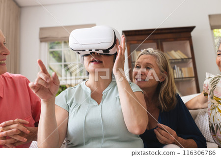 Diverse senior female friends enjoying VR at home 116306786