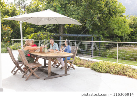 Diverse senior female friends enjoying meal outdoors, chatting happily, copy space Diverse senior female friends enjoying meal outdoors, chatting happily, copy space 116306914
