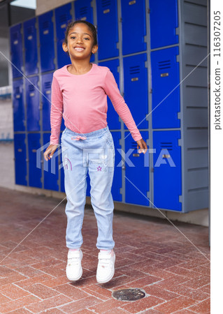 In school, young biracial girl wearing casual clothes is standing In school, young biracial girl wearing casual clothes is standing 116307205