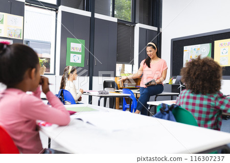 In school, a young biracial female teacher teaching a class In school, a young biracial female teacher teaching a class 116307237