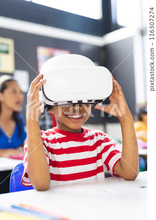 In school, young African American boy wearing a VR headset smiles in the classroom 116307274