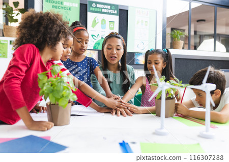 In school, diverse group of students and their teacher are engaging with plants in the classroom 116307288