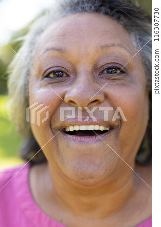 Outdoors, biracial senior woman wearing pink shirt, smiling 116307730