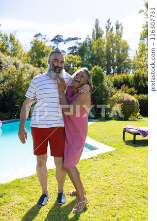 Outdoors, diverse senior friends, laughing near pool, wearing casual summer clothes 116307731