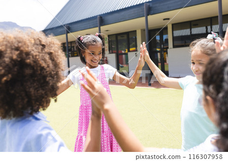 In school, two biracial girls and one biracial boy are playing outside In school, two biracial girls and one biracial boy are playing outside 116307958