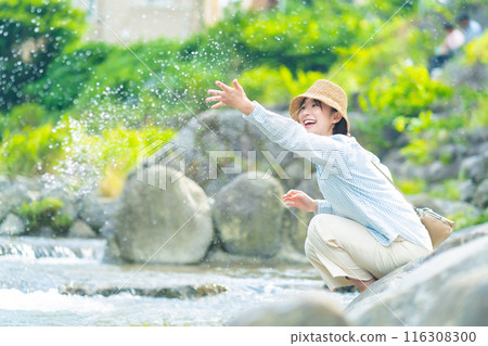A woman playing by the river, a woman traveling, a woman enjoying her holiday 116308300