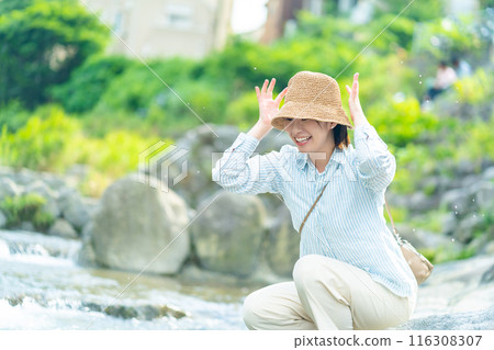 A woman playing by the river, a woman traveling, a woman enjoying her holiday 116308307