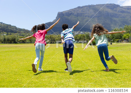 Three biracial children run across grassy field, full of joy Three biracial children run across grassy field, full of joy 116308534