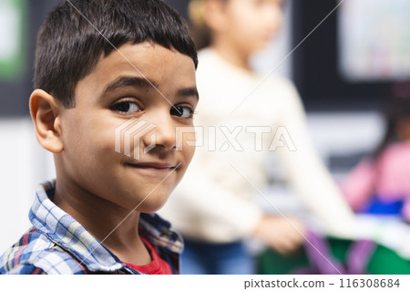 In school, in classroom, young biracial boy is smiling at the camera, copy space 116308684