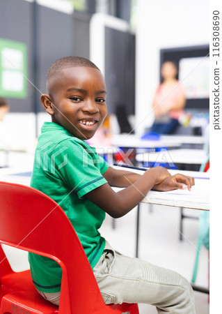 In school, young African American boy sitting in classroom, smiling at camera 116308690