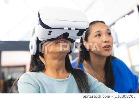 In school classroom, biracial teacher and her daughter explore virtual reality In school classroom, biracial teacher and her daughter explore virtual reality 116308703